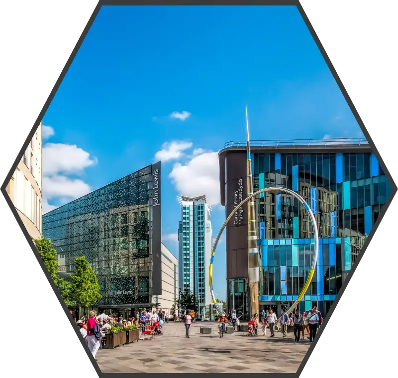 The Hayes area of Cardiff City centre on a sunny day. The Alliance sculpture and John Lewis Department store frame the background. 
